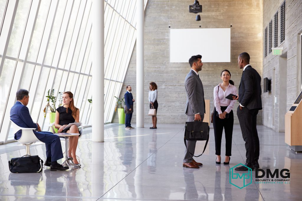 Professional concierge security guard greeting business executives in a modern office lobby