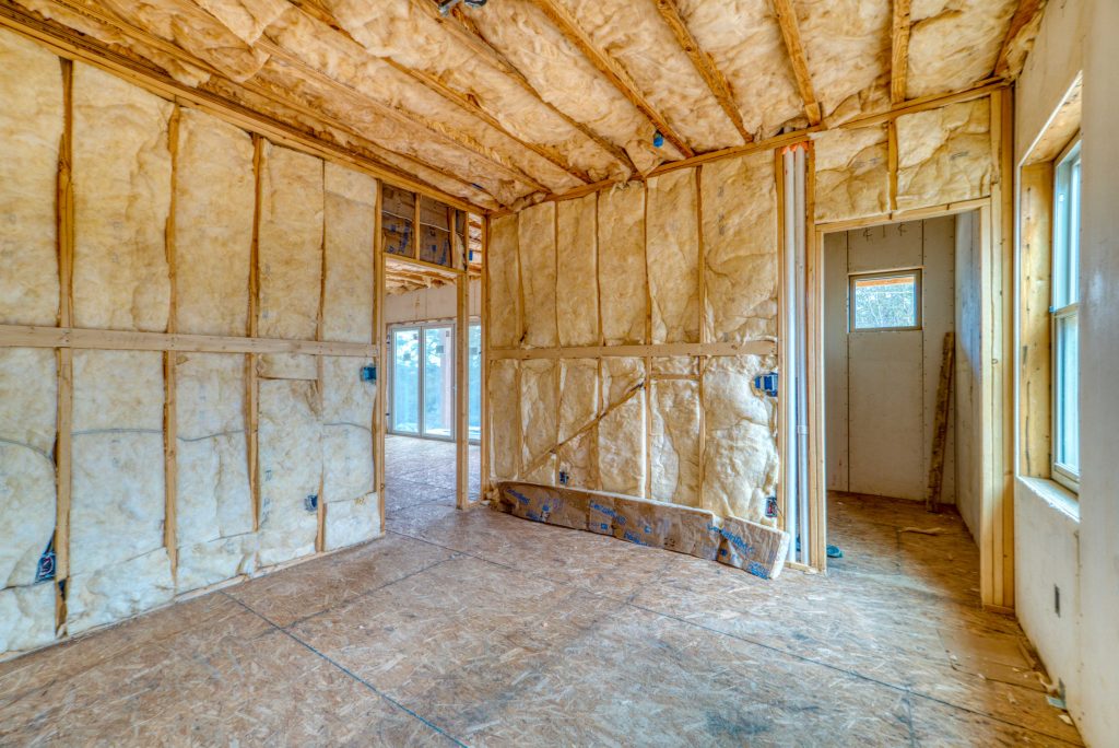 Unfinished construction site interior with exposed insulation and framing, vulnerable to copper theft